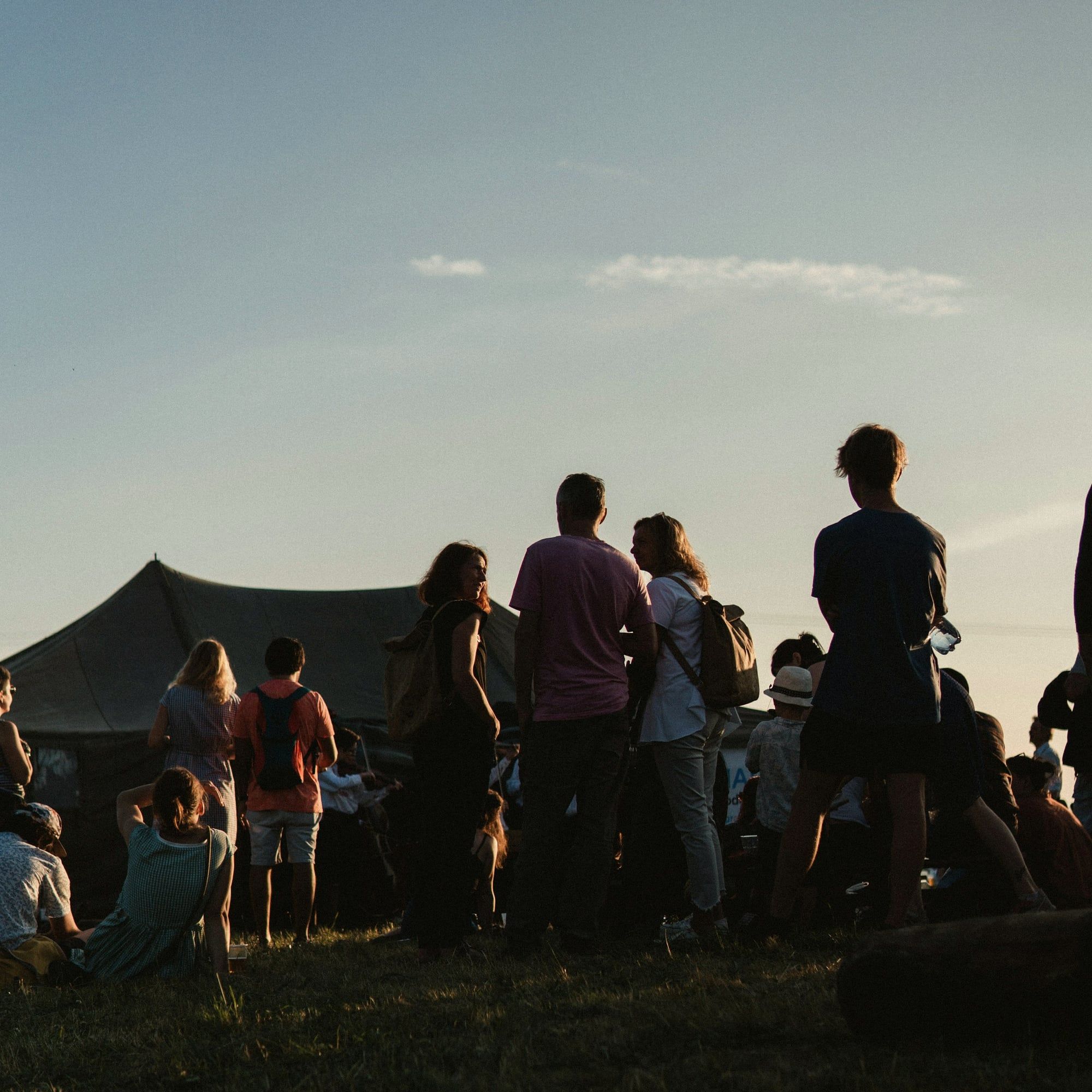 Gäste stehen in der Abendsonne vor einem Festzelt